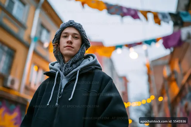 Young man standing in a street decorated with colorful flags