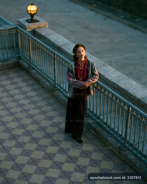 Woman standing on balcony wearing a stylish outfit