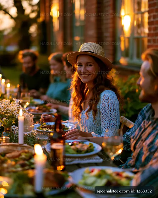 Outdoor dinner gathering at sunset with friends around table