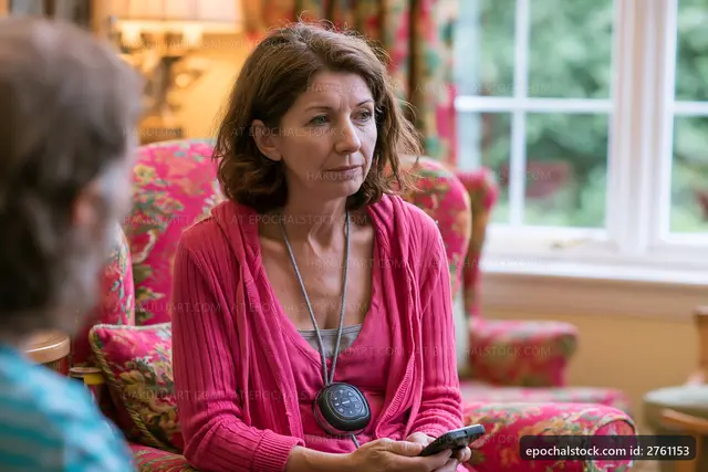 Woman sitting in a floral chair looking at her phone