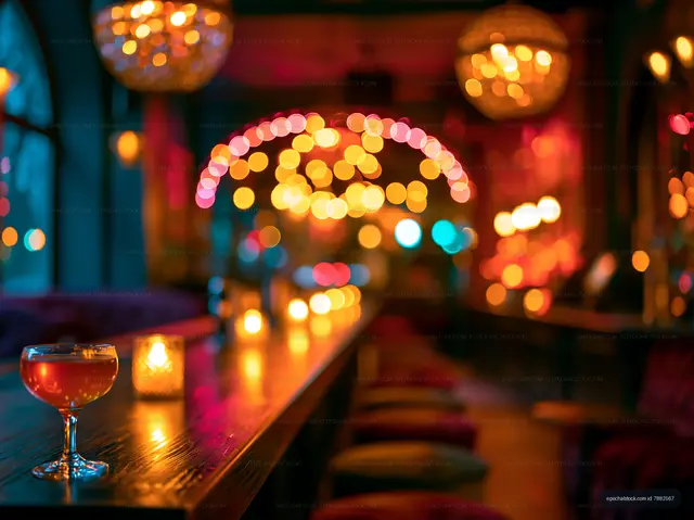 Dimly lit bar with cocktail and warm lights in the background