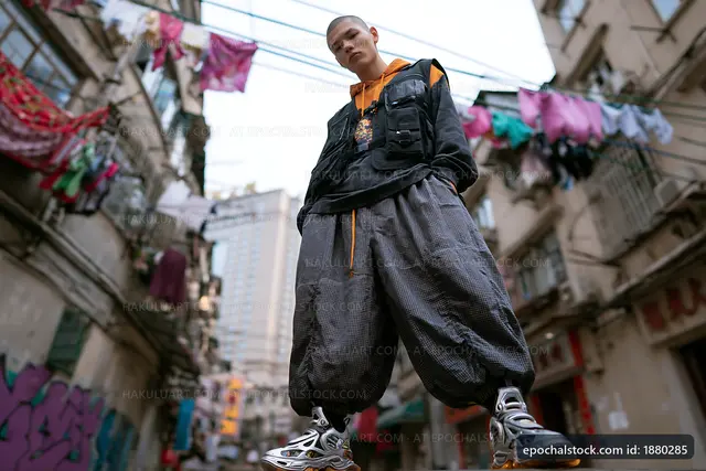 Young man in urban street with laundry hanging in background