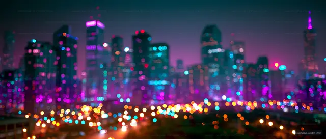 City skyline at night with colorful lights and bokeh effect