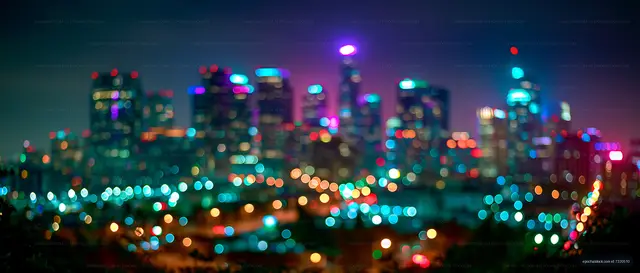City skyline at night with colorful lights and blurred effect
