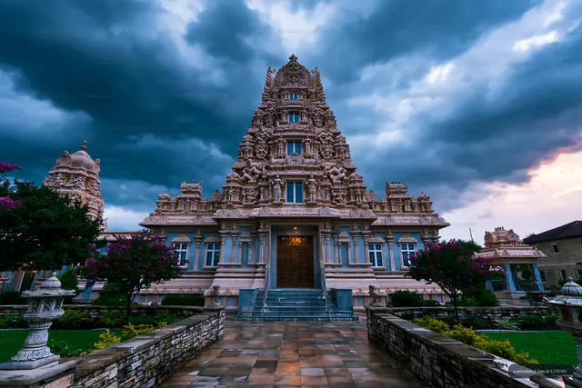 Sunset view of intricate temple structure with dark clouds