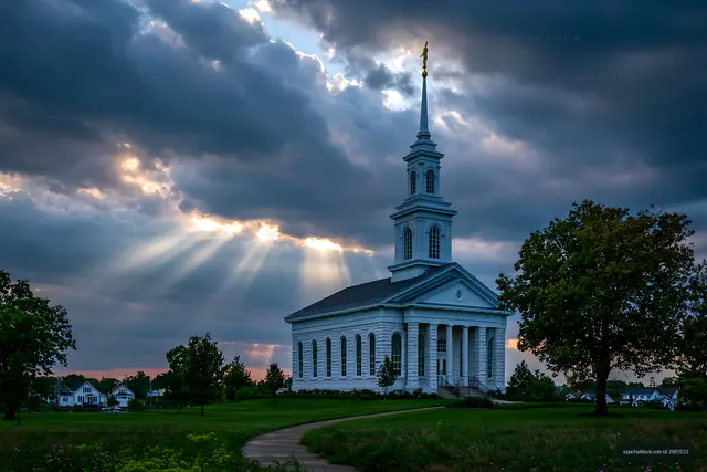 Church under cloudy sky with sunlight rays shining through