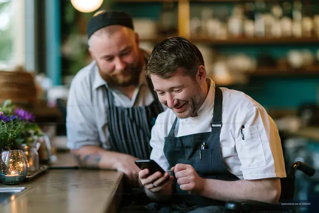 Chefs looking at phone in a casual restaurant setting