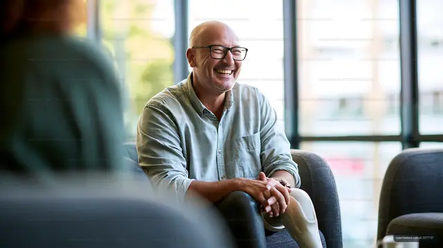 Smiling man enjoying conversation in a modern cafe setting