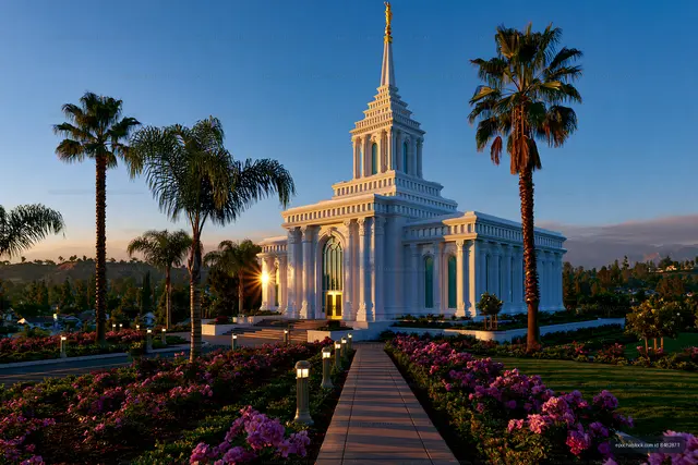 Sunset view of a temple with palm trees and colorful flowers