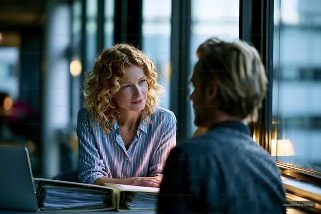 Two people discussing ideas in a modern office space