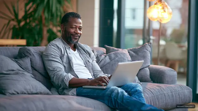 Man working on laptop while sitting on couch at home