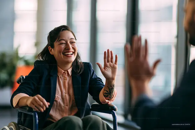 Smiling woman in wheelchair greeting a friend indoors