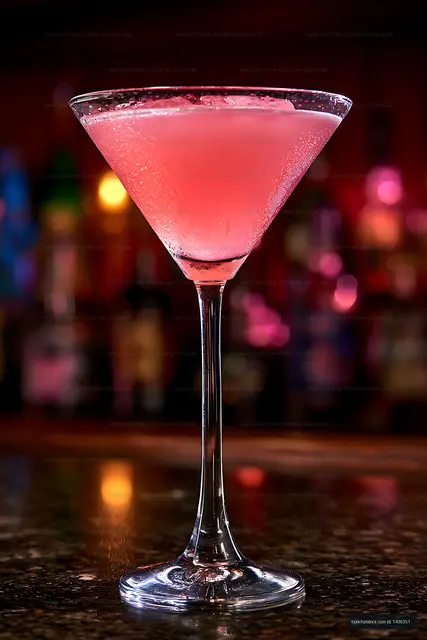 Pink cocktail with colorful bokeh in a bar setting