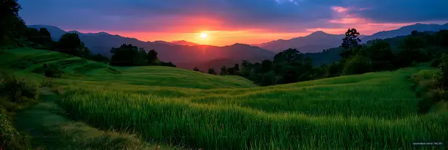 Vivid sunset over terraced farmland with distant mountains