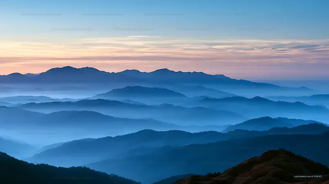 Atmospheric mountain ridges under a pastel evening sky