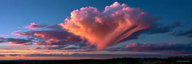 Towering illuminated clouds at sunset over the landscape