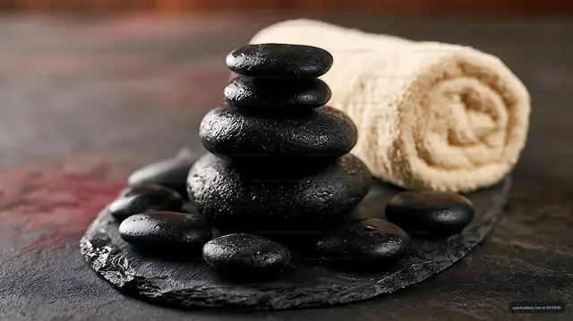 Zen stone stack with smooth black pebbles on slate