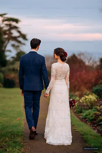Wedding couple walking away on a garden trail