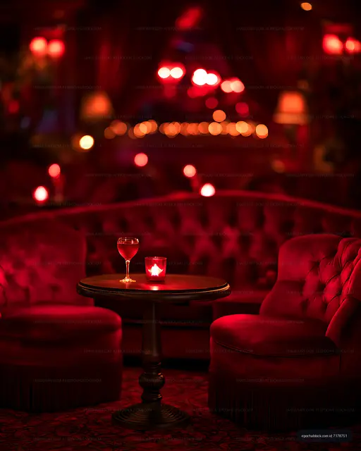 Intimate red-lit lounge with candle and wine glass