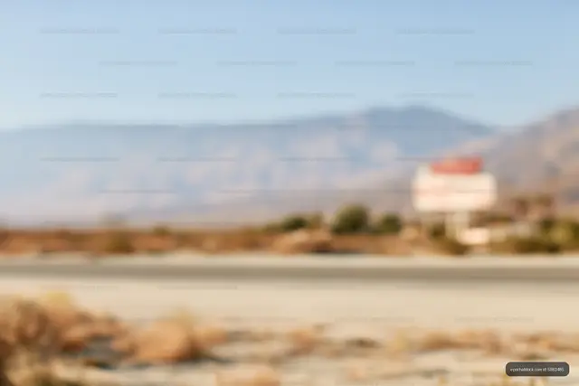 Defocused sandy roadside landscape with mountains