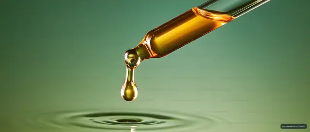 Luminous liquid drop above green ripples