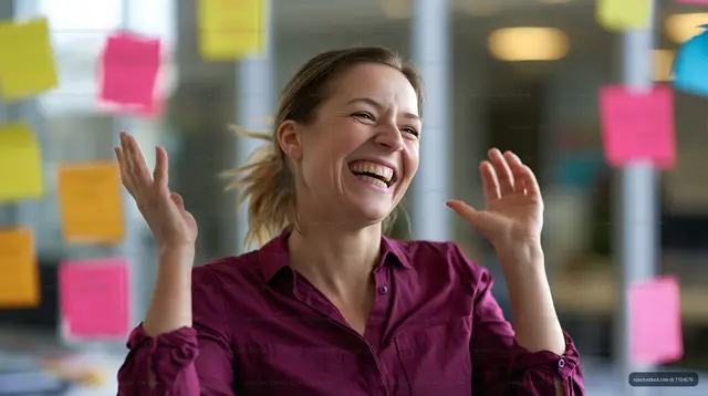 Laughing woman celebrating in a colorful modern workspace