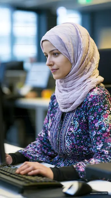Woman wearing a lavender hijab using a computer